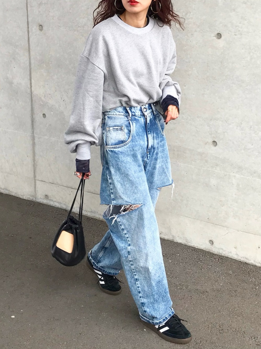 グレー系のスウェット、ブラック系のTシャツ/カットソー、ブルー系のデニムパンツを着用したレディースの冬コーディネートの2枚目の写真