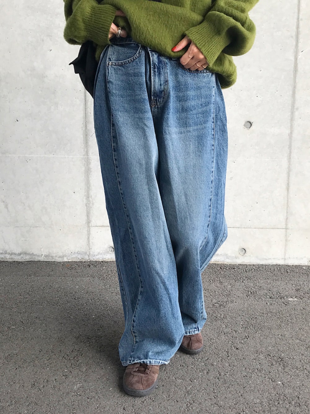 グリーン系のニット/セーター、ホワイト系のTシャツ/カットソー、ブラック系のショルダーバッグを着用したレディースの秋コーディネートの2枚目の写真