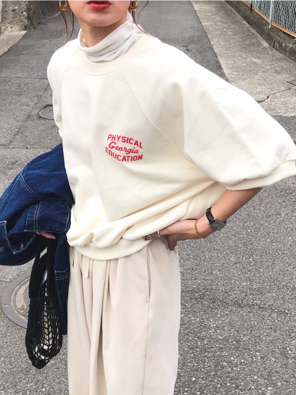 ブルー系のデニムジャケット、ホワイト系のスウェット、ホワイト系のスウェットパンツを着用したレディースの春コーディネートの2枚目の写真