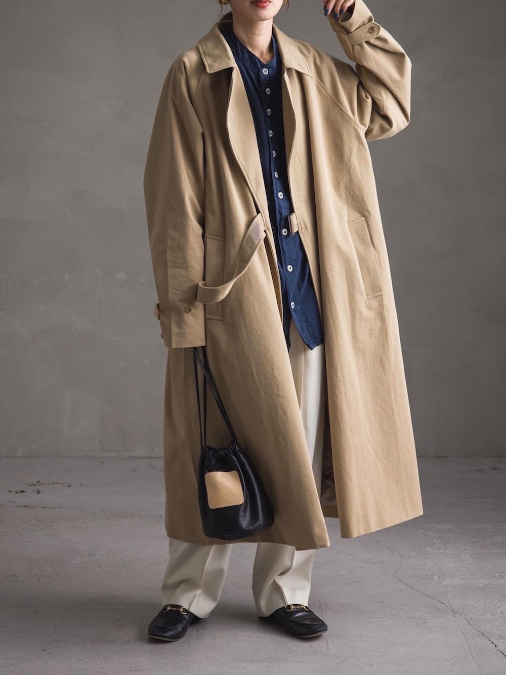 ベージュ系のトレンチコート、ブルー系のシャツ/ブラウス、ホワイト系のパンツを着用したレディースの冬コーディネートの2枚目の写真