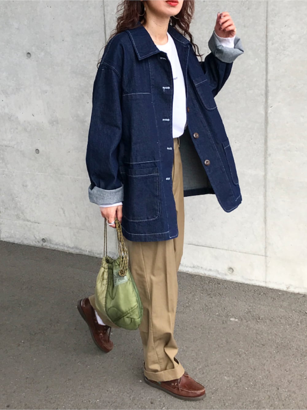 ブルー系のデニムジャケット、ホワイト系のTシャツ/カットソー、ベージュ系のチノパンツを着用したレディースの冬コーディネートの2枚目の写真