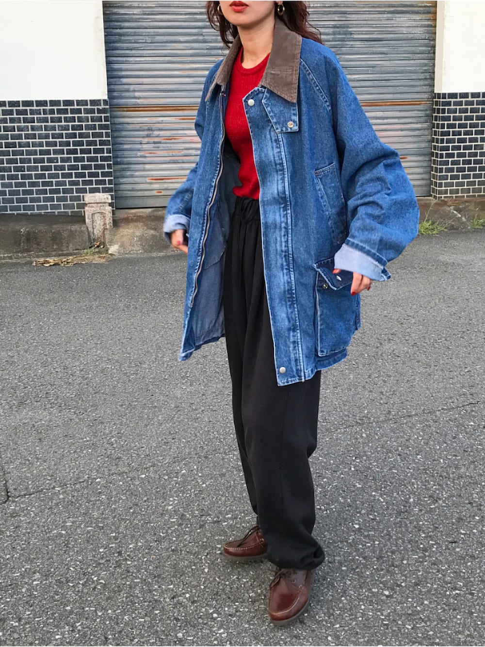 ブルー系のデニムジャケット、レッド系のニット/セーター、ブラック系のパンツを着用したレディースの秋コーディネートの2枚目の写真