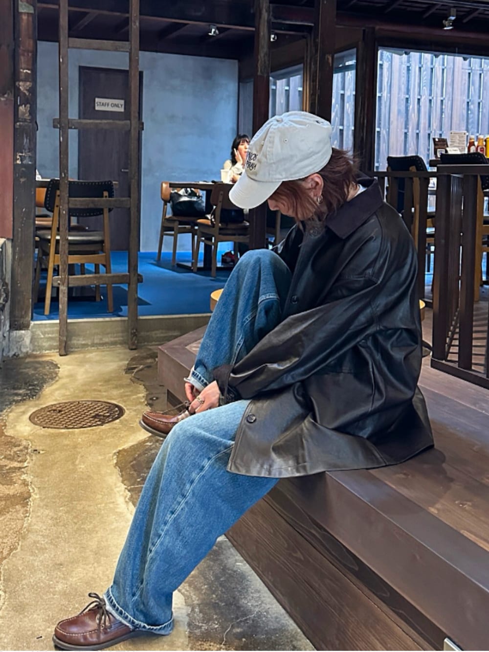 ブラウン系のモカシン/デッキシューズ、ブラウン系のジャケット/アウター、ブルー系のデニムパンツを着用したレディースの秋コーディネートの2枚目の写真