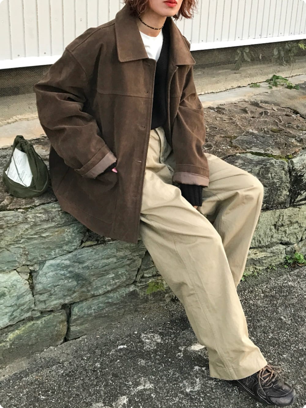 ホワイト系のTシャツ/カットソー、ブラック系のニット/セーター、ブラウン系のジャケット/アウターを着用したレディースの秋コーディネートの2枚目の写真