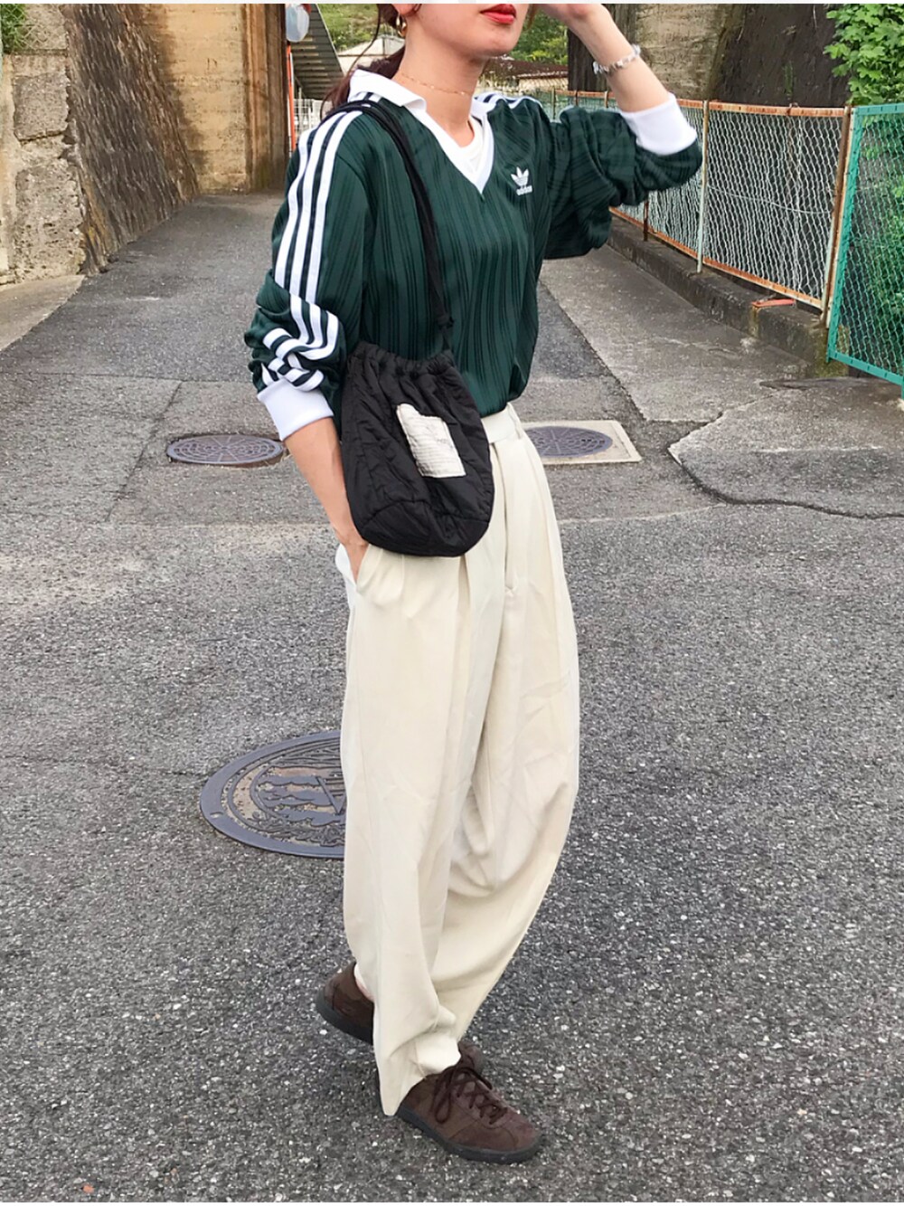 グリーン系のTシャツ/カットソー、ホワイト系のパンツ、ブラック系のショルダーバッグを着用したレディースの夏コーディネートの2枚目の写真