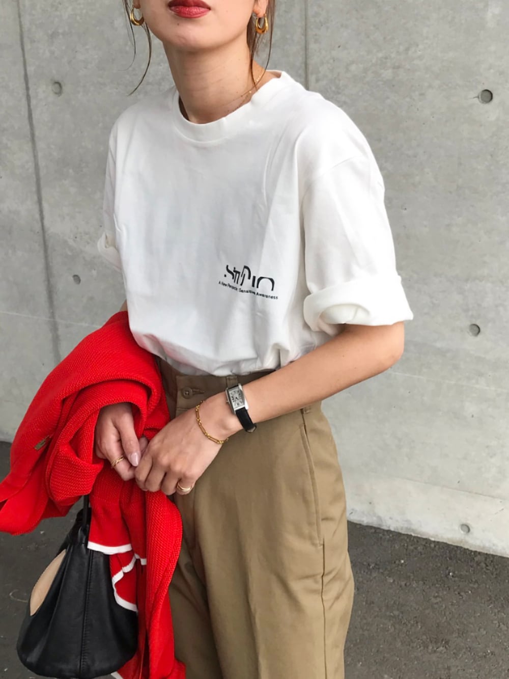 ホワイト系のTシャツ/カットソー、ベージュ系のチノパンツ、ブラック系のショルダーバッグを着用したレディースの春コーディネートの2枚目の写真