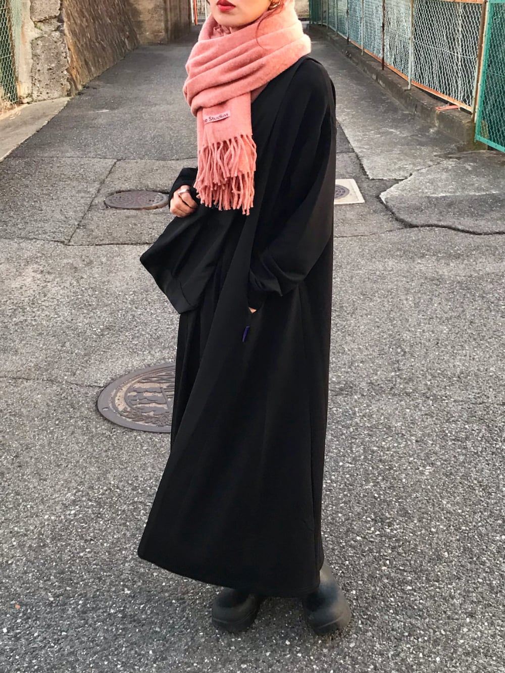 ブラック系のワンピース、ブラック系のショルダーバッグ、ブラック系のブーツを着用したレディースの秋コーディネートの2枚目の写真