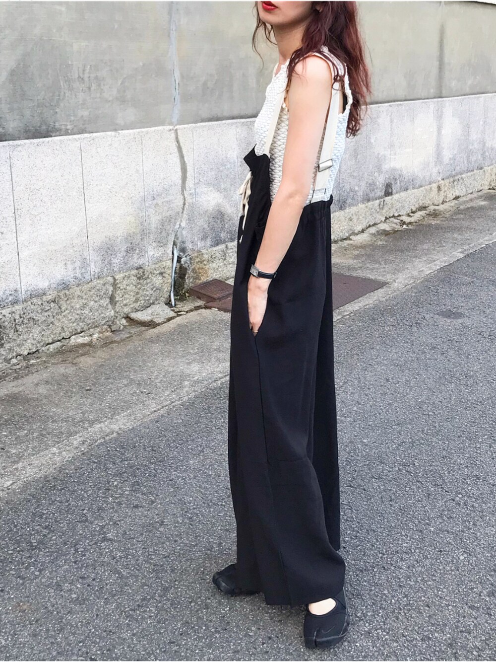 ブラック系のオールインワン・サロペット、ホワイト系のタンクトップ、ブラック系のサンダルを着用したレディースの夏コーディネートの2枚目の写真