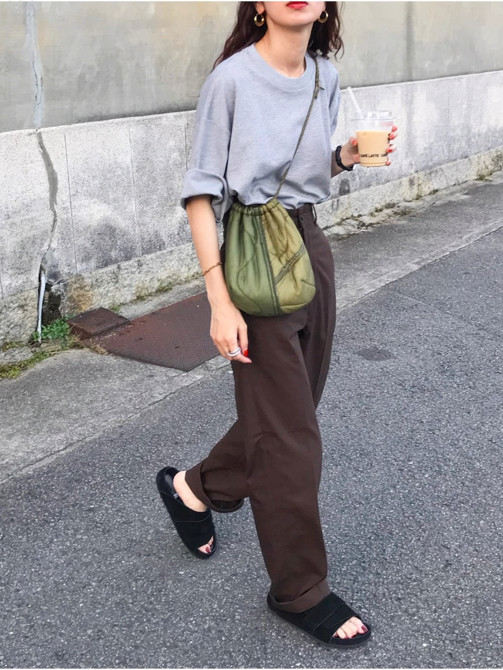グレー系のTシャツ/カットソー、ブラウン系のチノパンツ、ブラック系のサンダルを着用したレディースの夏コーディネートの2枚目の写真