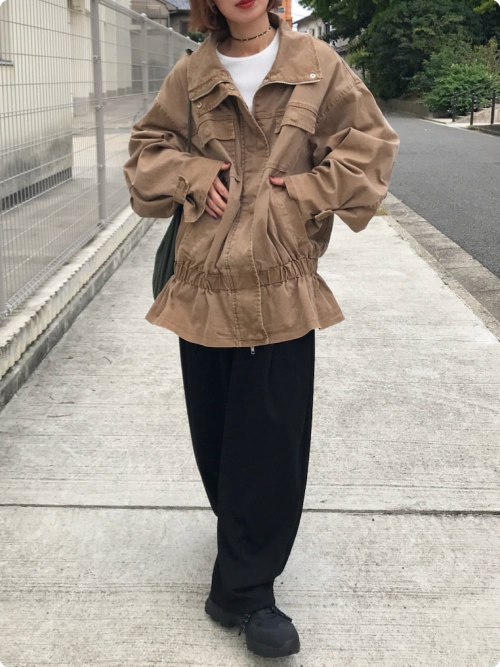 ブラウン系のブルゾン、ホワイト系のTシャツ/カットソー、ブラック系のスウェットパンツを着用したレディースの秋コーディネートの3枚目の写真