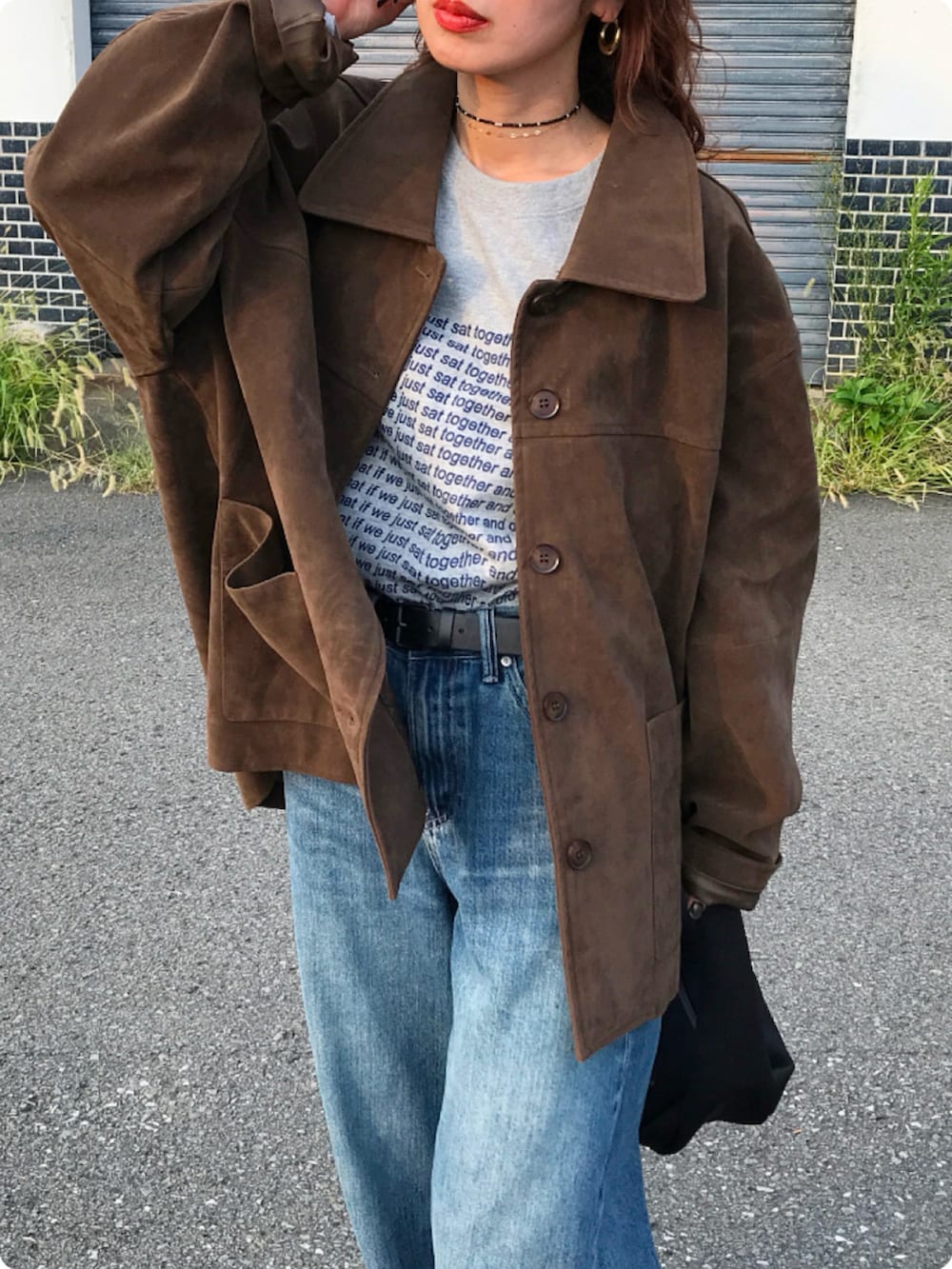 ブラック系のハンドバッグ、ブラウン系のモカシン/デッキシューズ、グレー系のTシャツ/カットソーを着用したレディースの秋コーディネートの3枚目の写真