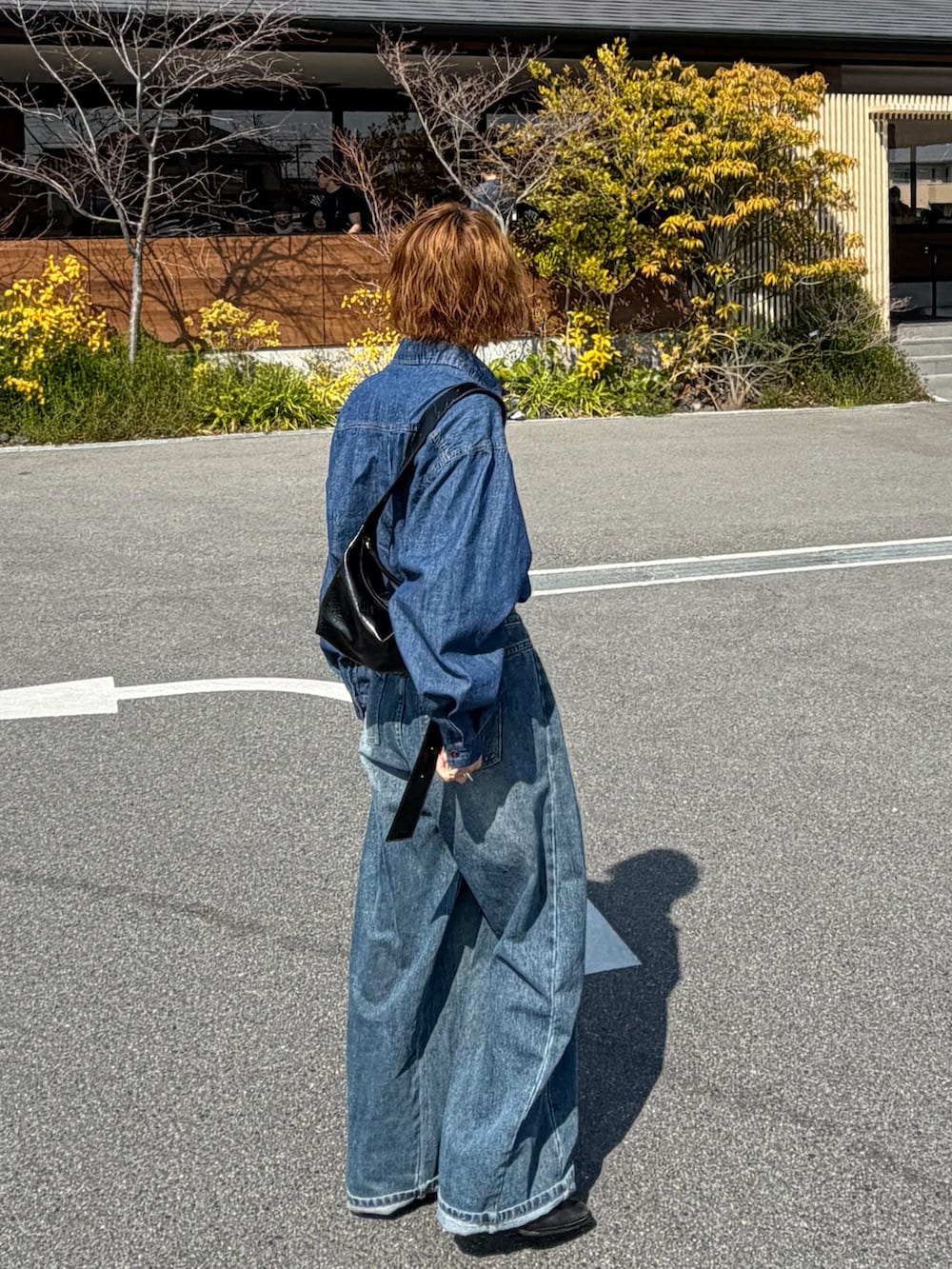 グリーン系のその他アウター、ブラック系のブーツ、ブルー系のシャツ/ブラウスを着用したレディースの春コーディネートの2枚目の写真