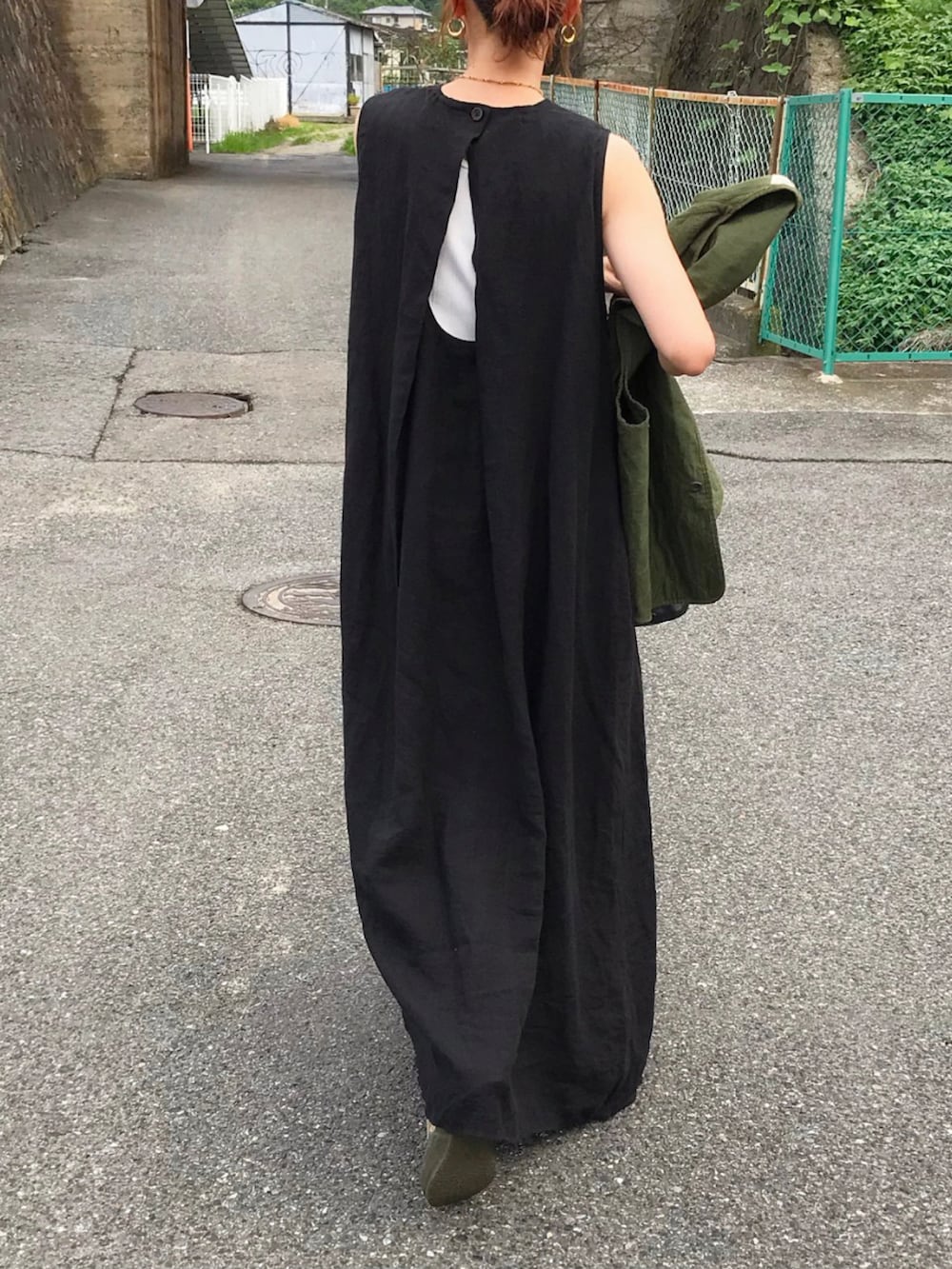 ブラック系のワンピース、グリーン系のベスト、ベージュ系のスニーカーを着用したレディースの夏コーディネートの2枚目の写真