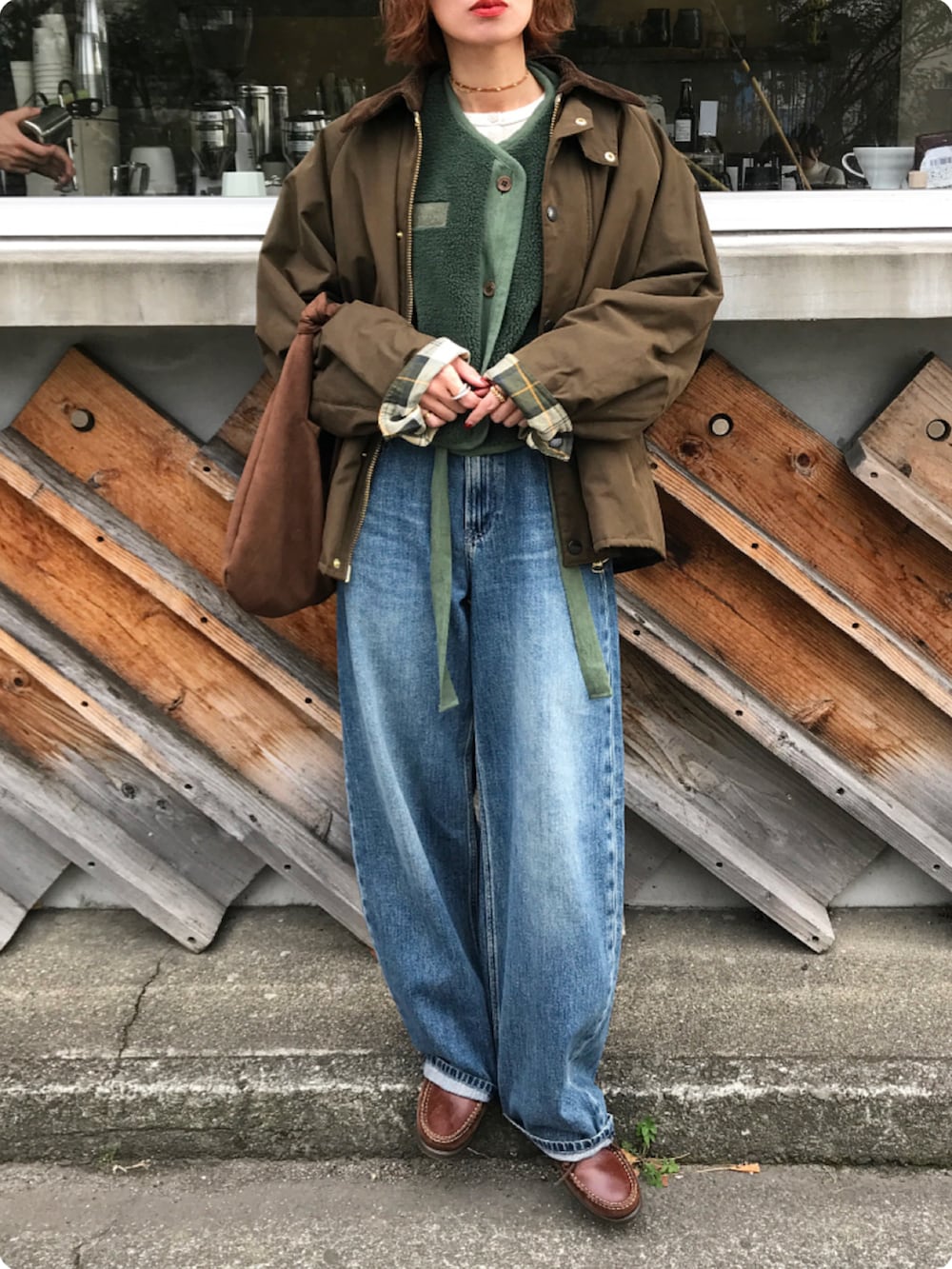 グリーン系のその他アウター、ブラウン系のモカシン/デッキシューズ、グリーン系のベストを着用したレディースの冬コーディネートの2枚目の写真