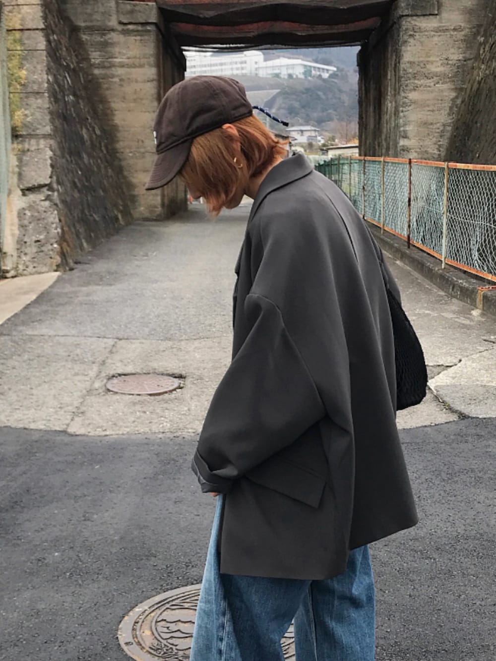 グレー系のテーラードジャケット、グレー系のスウェット、ブルー系のデニムパンツを着用したレディースの冬コーディネートの3枚目の写真