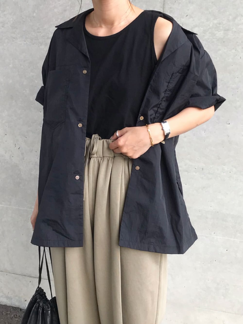 ブラック系のシャツ/ブラウス、ブラック系のタンクトップ、ベージュ系のスウェットパンツを着用したレディースの春コーディネートの3枚目の写真