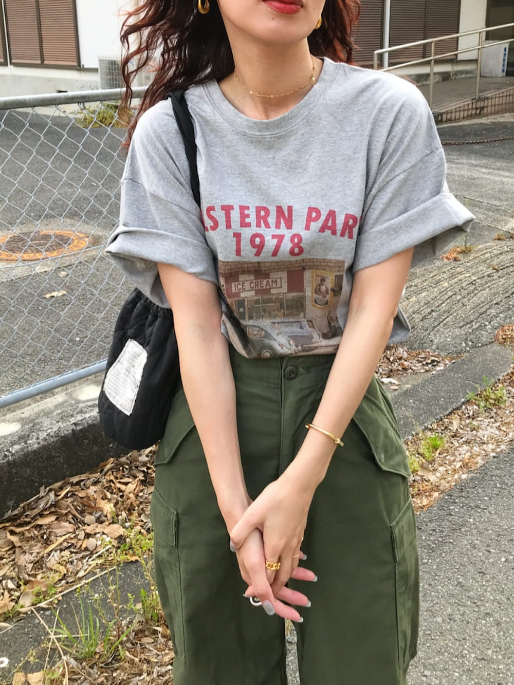 ホワイト系のベスト、グレー系のTシャツ/カットソー、グリーン系のカーゴパンツを着用したレディースの春コーディネートの2枚目の写真