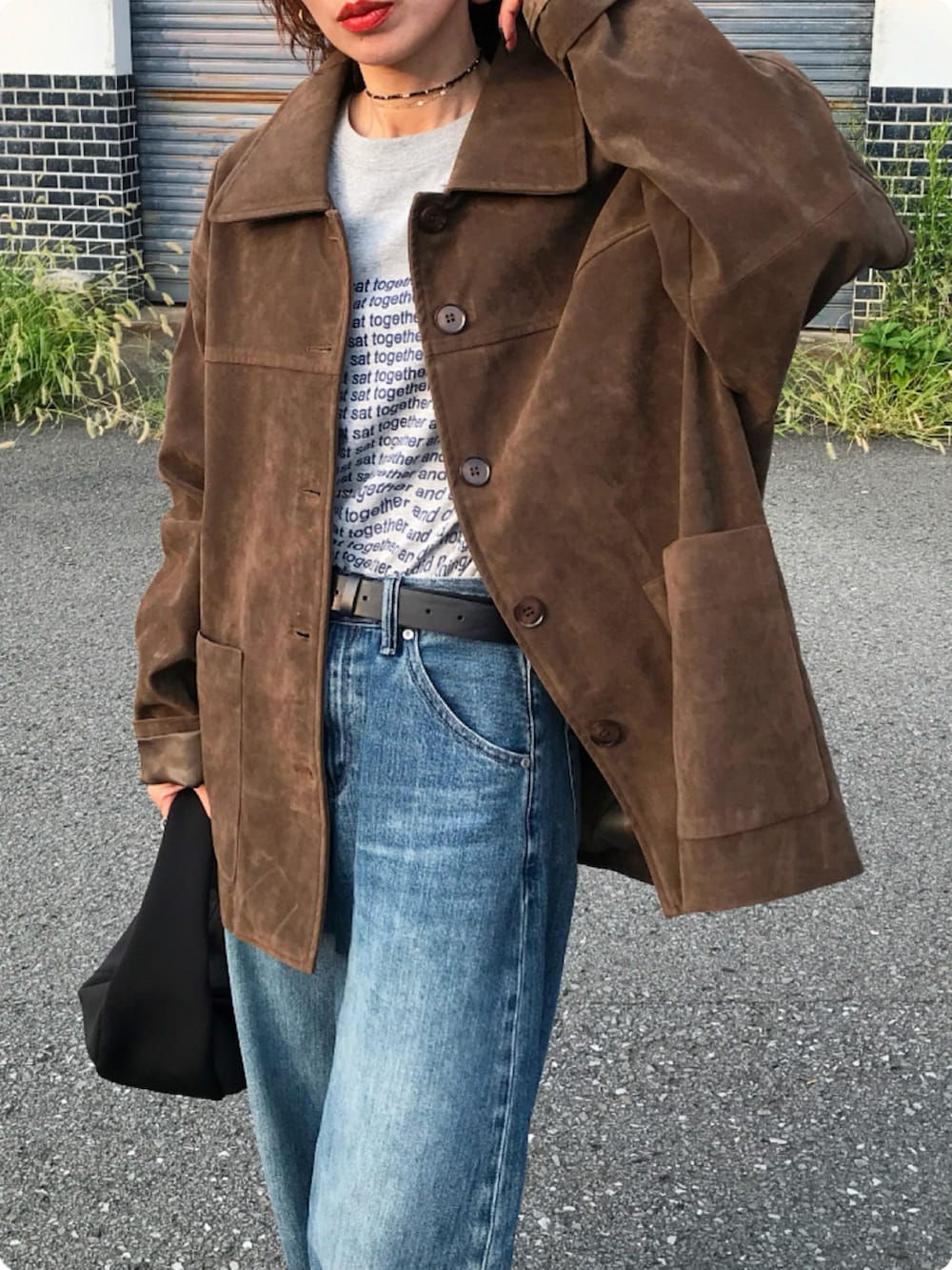 ブラック系のハンドバッグ、ブラウン系のモカシン/デッキシューズ、グレー系のTシャツ/カットソーを着用したレディースの秋コーディネートの2枚目の写真