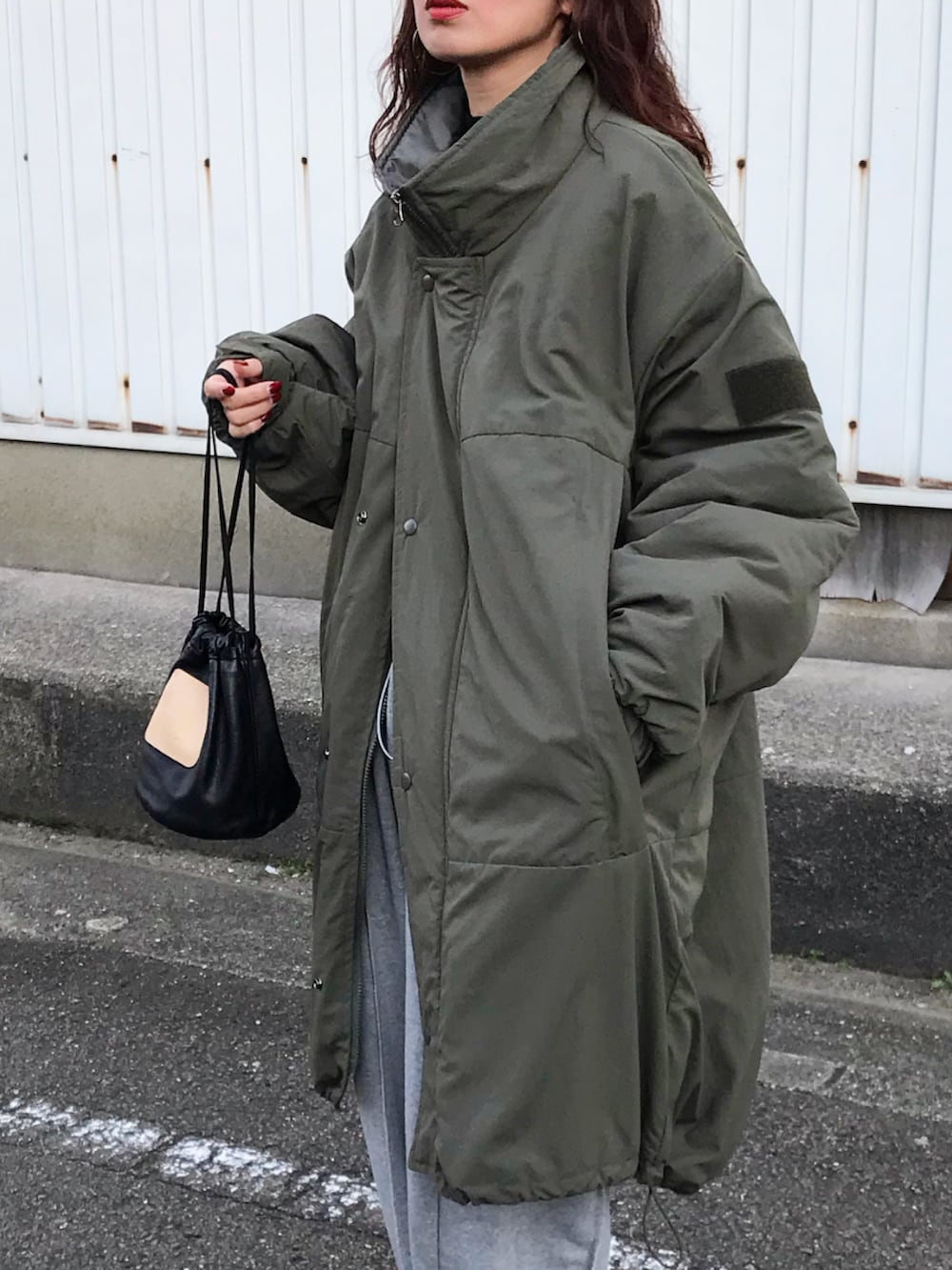 グリーン系のその他アウター、グレー系のスウェットパンツ、ブラック系のショルダーバッグを着用したレディースの秋コーディネートの2枚目の写真