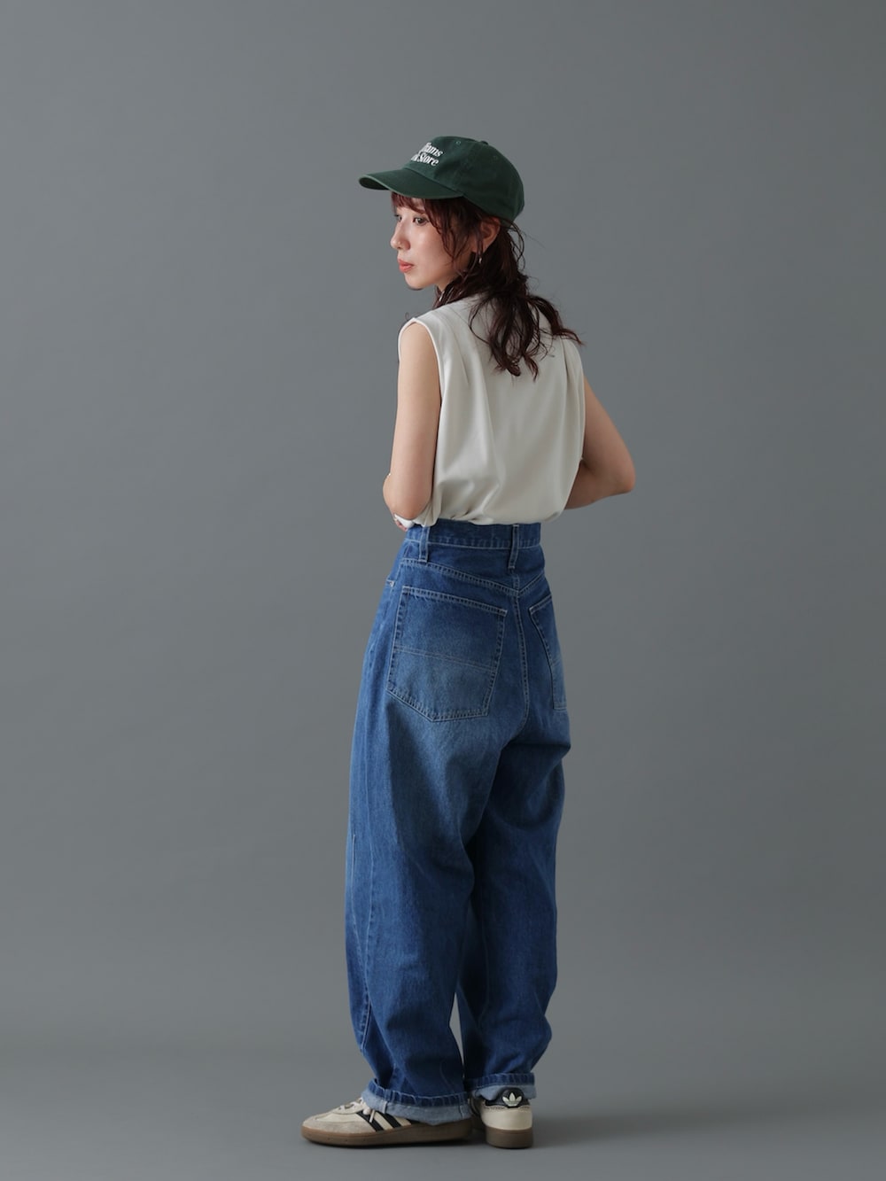 ブルー系のデニムパンツ、ホワイト系のトップス、ホワイト系のスニーカーを着用したレディースの春コーディネートの2枚目の写真