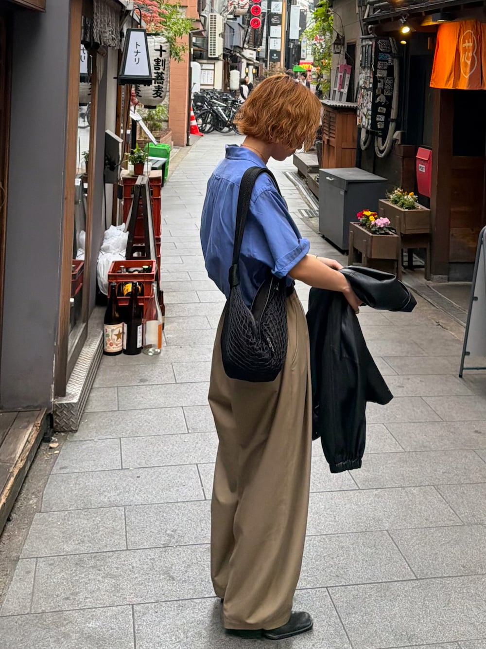 ブルー系のシャツ/ブラウス、ベージュ系のパンツ、ブラック系のショルダーバッグを着用したレディースの春コーディネートの2枚目の写真