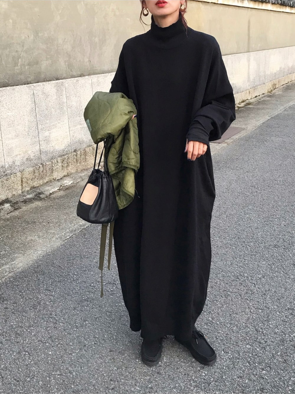 ブラック系のワンピース、ブラック系のTシャツ/カットソー、グリーン系のベストを着用したレディースの秋コーディネートの2枚目の写真