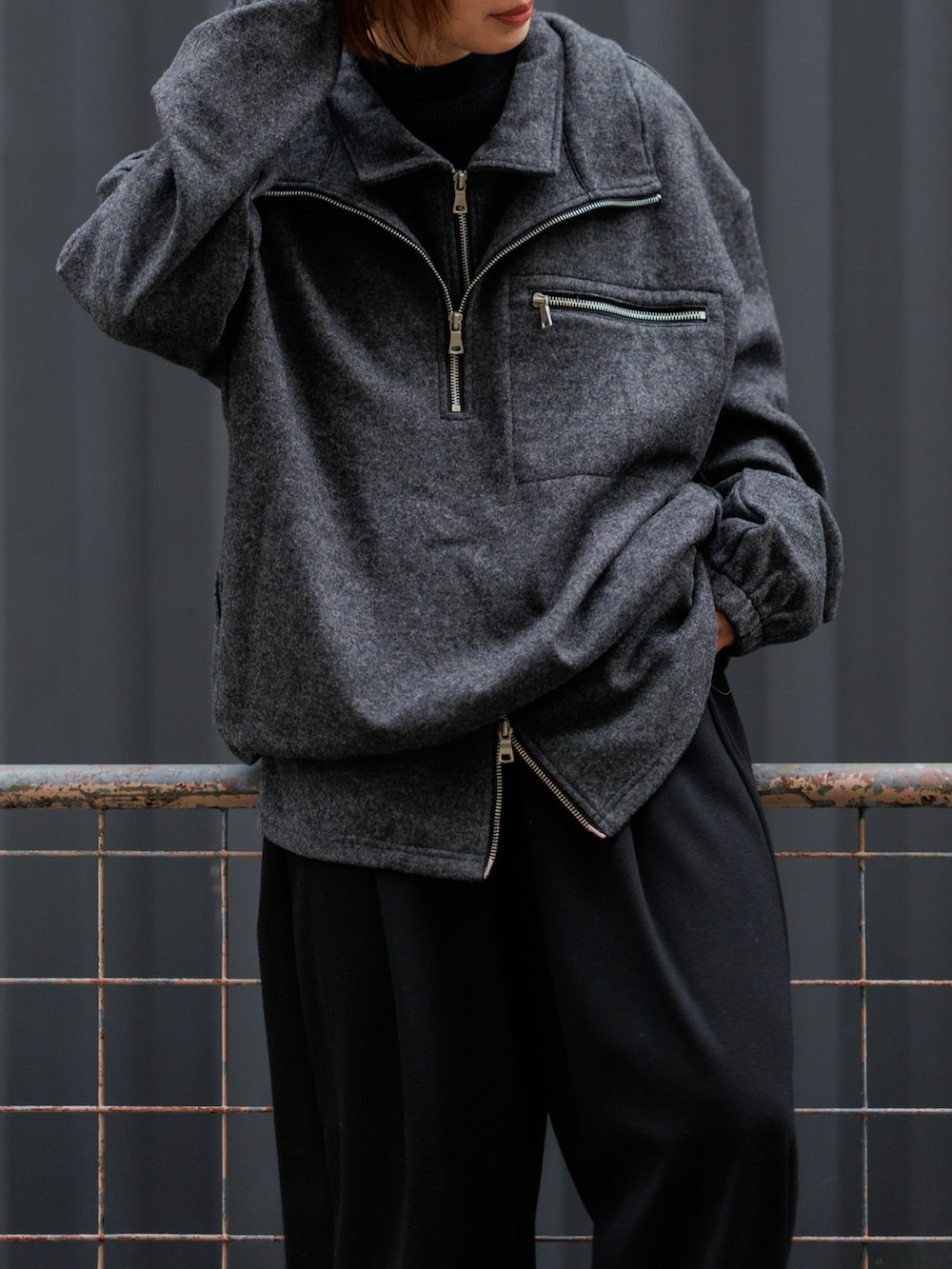 グレー系のスニーカー、グレー系のトップス、ブラック系のスウェットパンツを着用したレディースの冬コーディネートの3枚目の写真