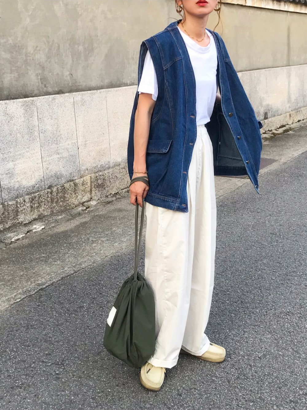 ブルー系のベスト、ホワイト系のTシャツ/カットソー、ホワイト系のパンツを着用したレディースの夏コーディネートの2枚目の写真