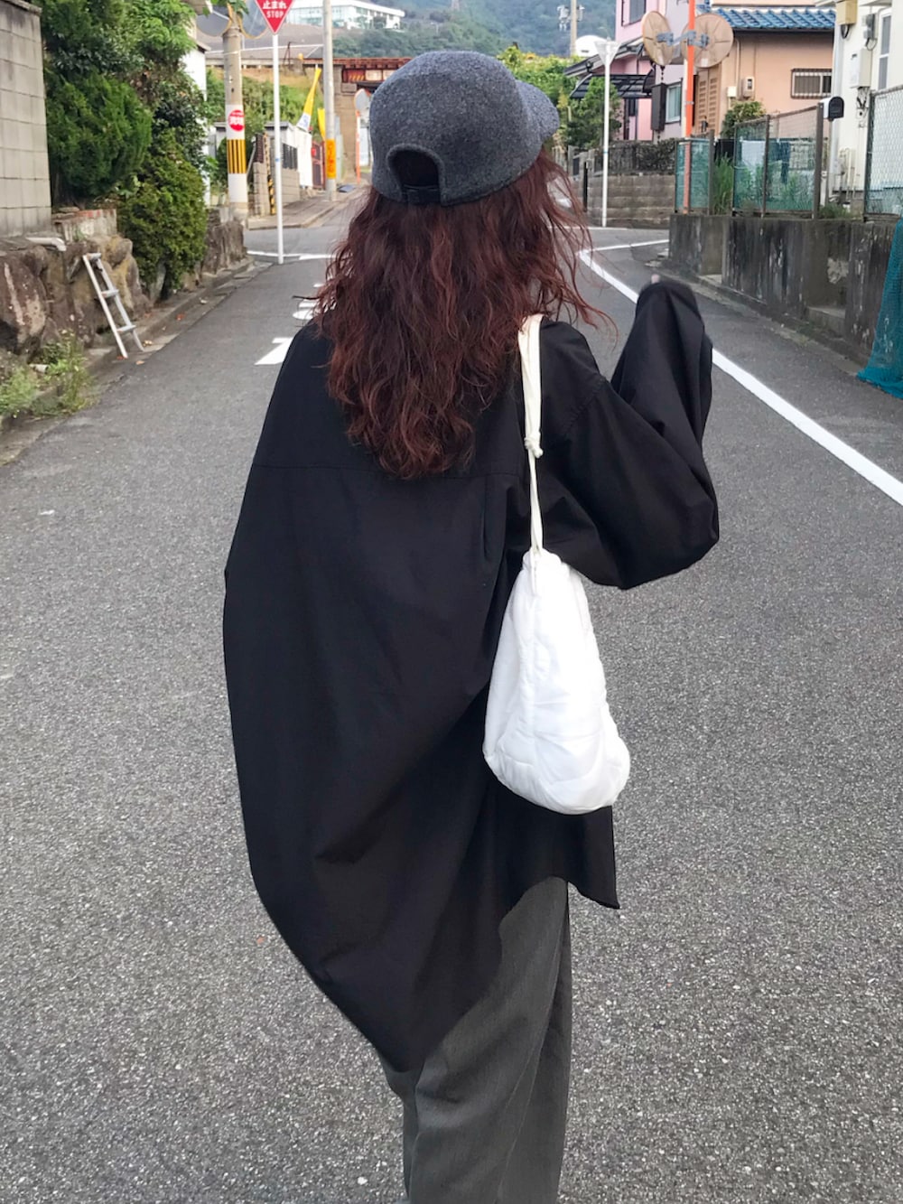 ブラック系のシャツ/ブラウス、グレー系のパンツ、グリーン系のショルダーバッグを着用したレディースの秋コーディネートの3枚目の写真