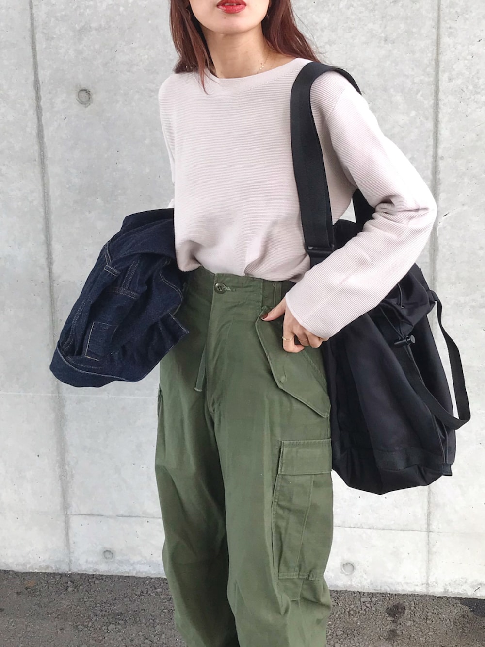 グレー系のニット/セーター、ブルー系のデニムジャケット、グリーン系のカーゴパンツを着用したレディースの冬コーディネートの2枚目の写真