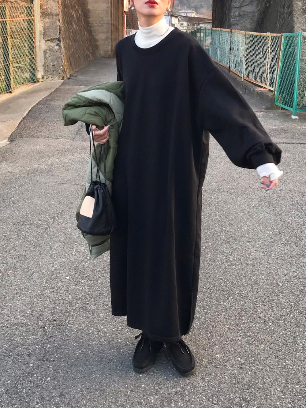 グリーン系のジャケット/アウター、ブラック系のワンピース/ドレス、ホワイト系のTシャツ/カットソーを着用したレディースの冬コーディネートの2枚目の写真