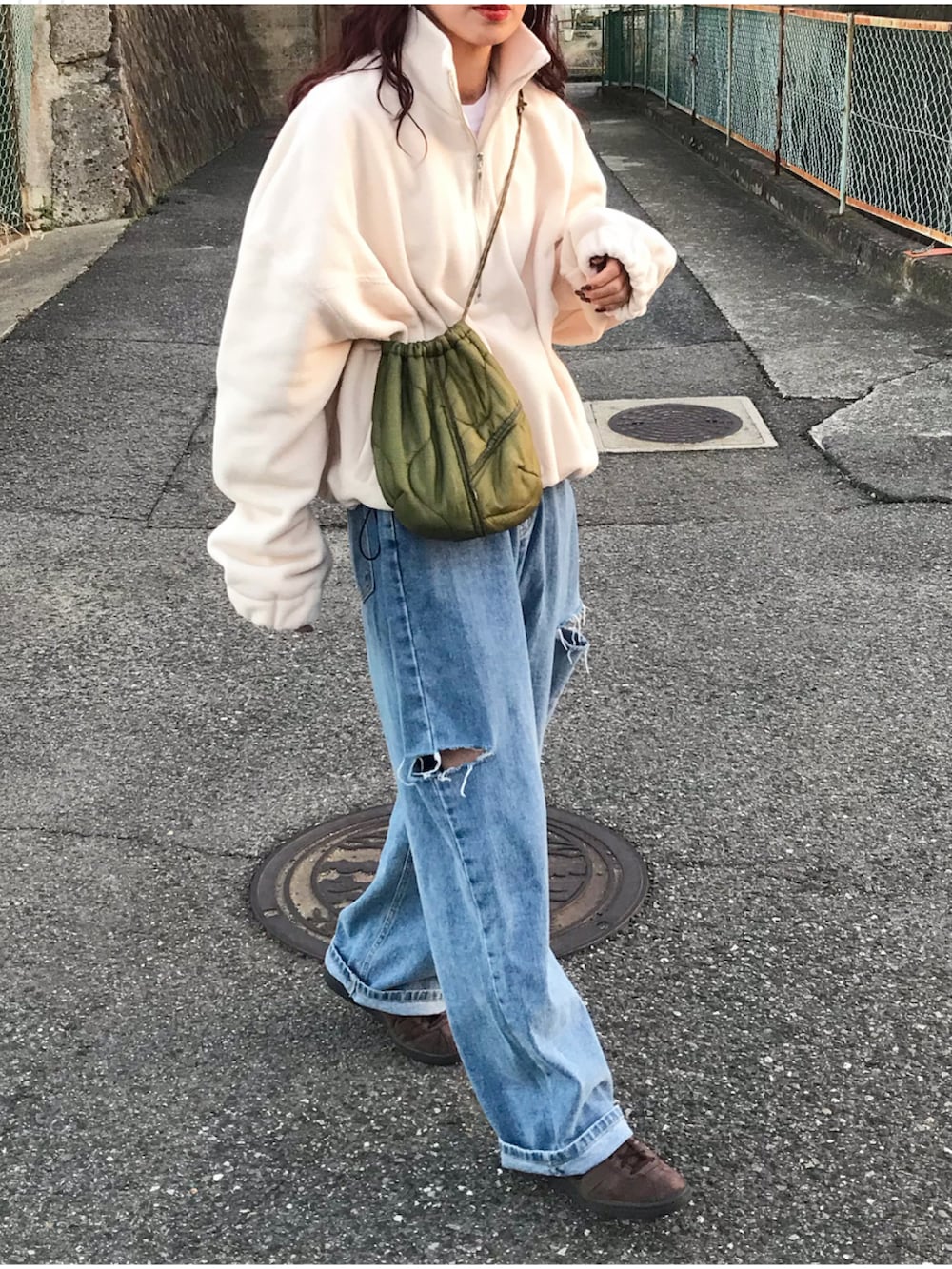 ホワイト系のその他トップス、ブルー系のデニムパンツ、ブラウン系のスニーカーを着用したレディースの冬コーディネートの2枚目の写真