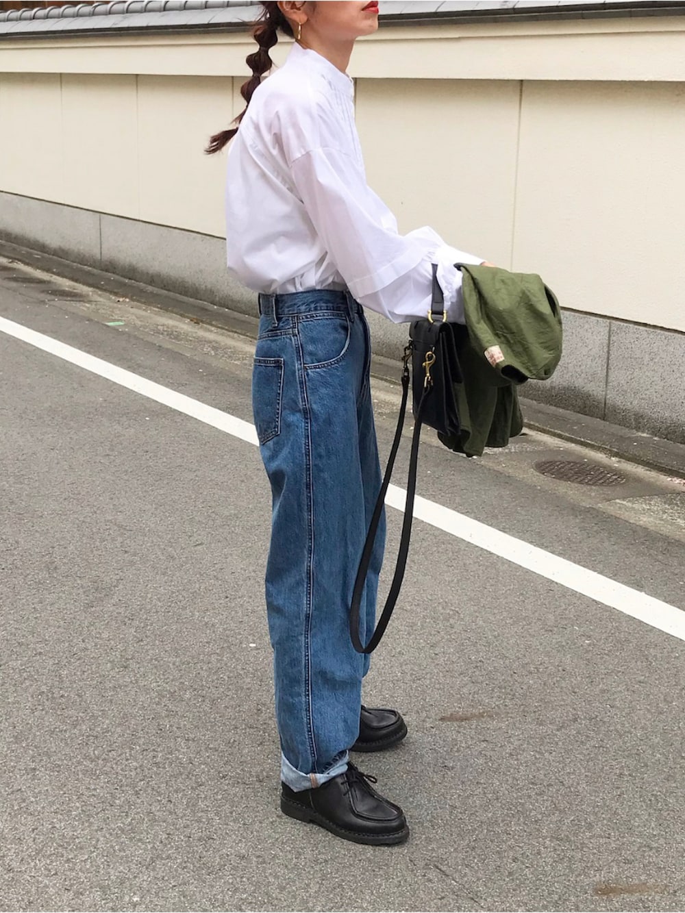 グリーン系のベスト、ホワイト系のシャツ/ブラウス、ブルー系のデニムパンツを着用したレディースの春コーディネートの2枚目の写真