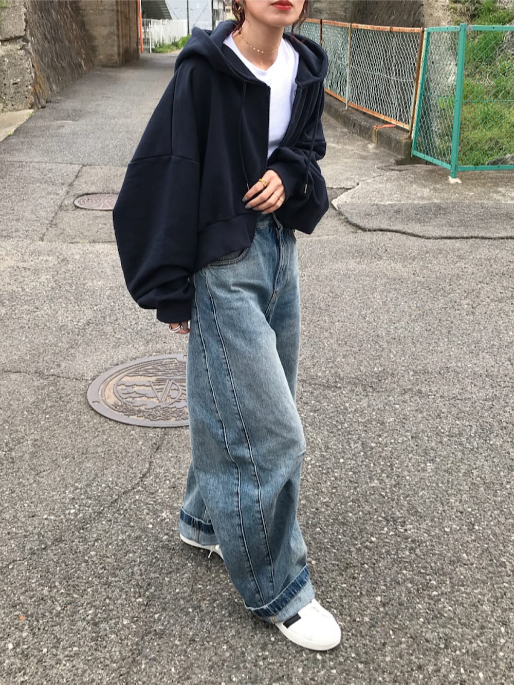 ブルー系のパーカー、ホワイト系のTシャツ/カットソー、ブルー系のデニムパンツを着用したレディースの春コーディネートの2枚目の写真