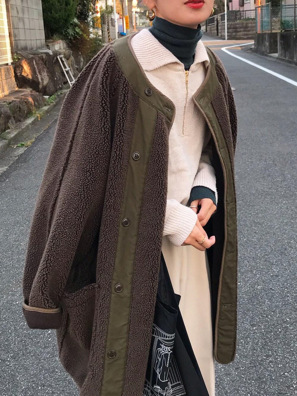 グリーン系のジャケット/アウター、ホワイト系のニット/セーター、グリーン系のトップスを着用したレディースの冬コーディネートの2枚目の写真
