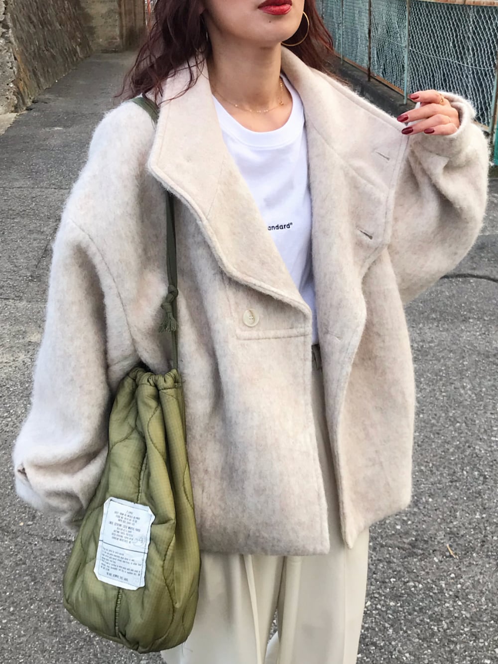 ベージュ系のジャケット/アウター、ホワイト系のTシャツ/カットソー、ホワイト系のパンツを着用したレディースの秋コーディネートの2枚目の写真