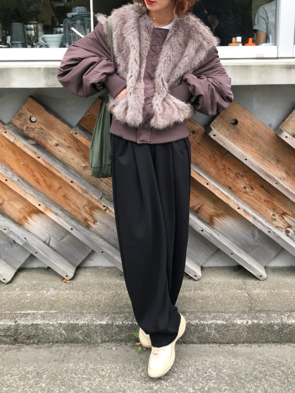 ブラウン系のMA-1、ブラック系のスウェットパンツ、グリーン系のバッグを着用したレディースの秋コーディネートの2枚目の写真