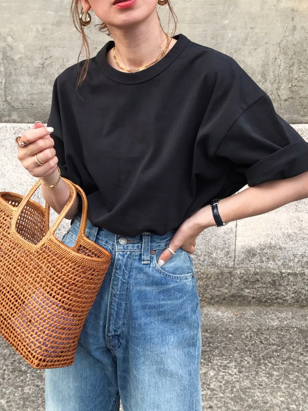 ブラック系のTシャツ/カットソー、ブルー系のデニムパンツ、その他のかごバッグを着用したレディースの夏コーディネートの2枚目の写真