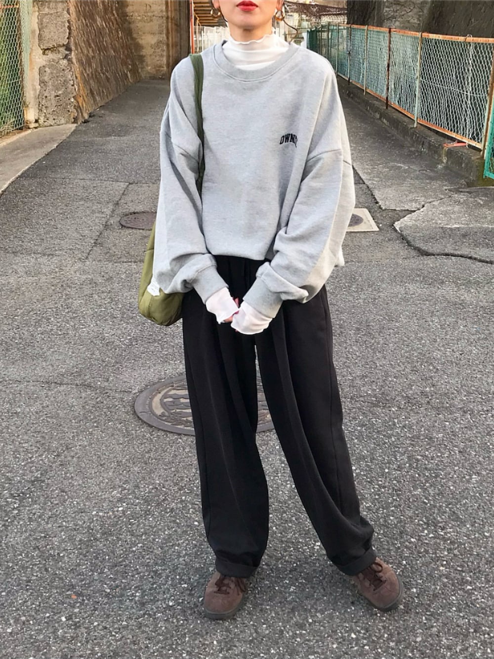 グレー系のスウェット、ホワイト系のTシャツ/カットソー、ブラック系のパンツを着用したレディースの冬コーディネートの2枚目の写真