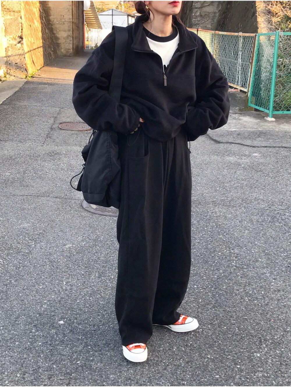 ホワイト系のTシャツ/カットソー、ブラック系のスウェットパンツ、ブラック系のショルダーバッグを着用したレディースの春コーディネートの2枚目の写真