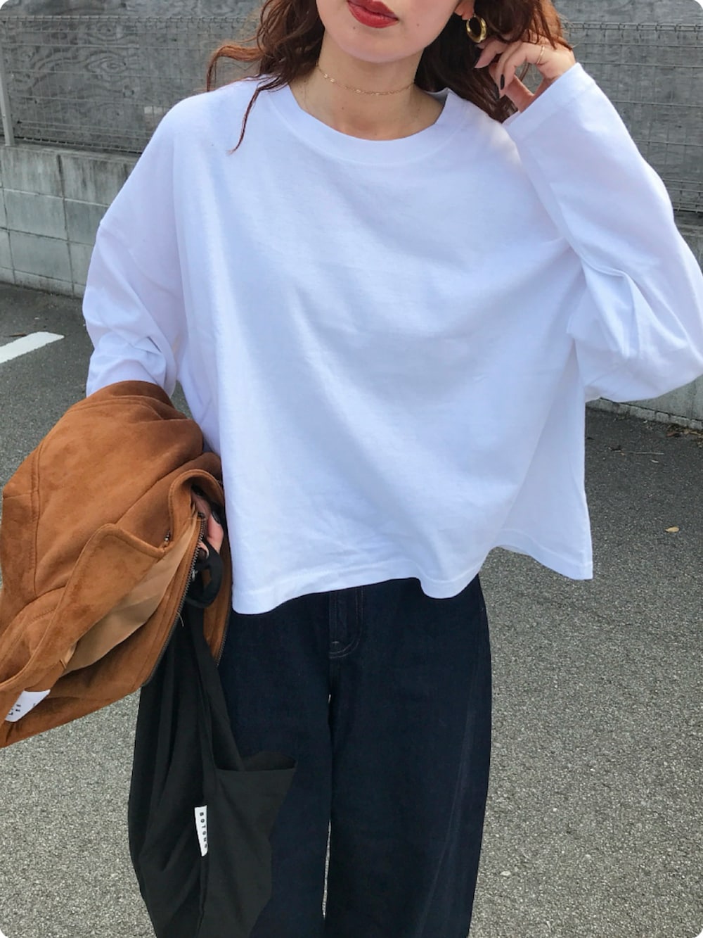 ホワイト系のTシャツ/カットソー、ブルー系のデニムパンツ、レッド系のスニーカーを着用したレディースの秋コーディネートの2枚目の写真
