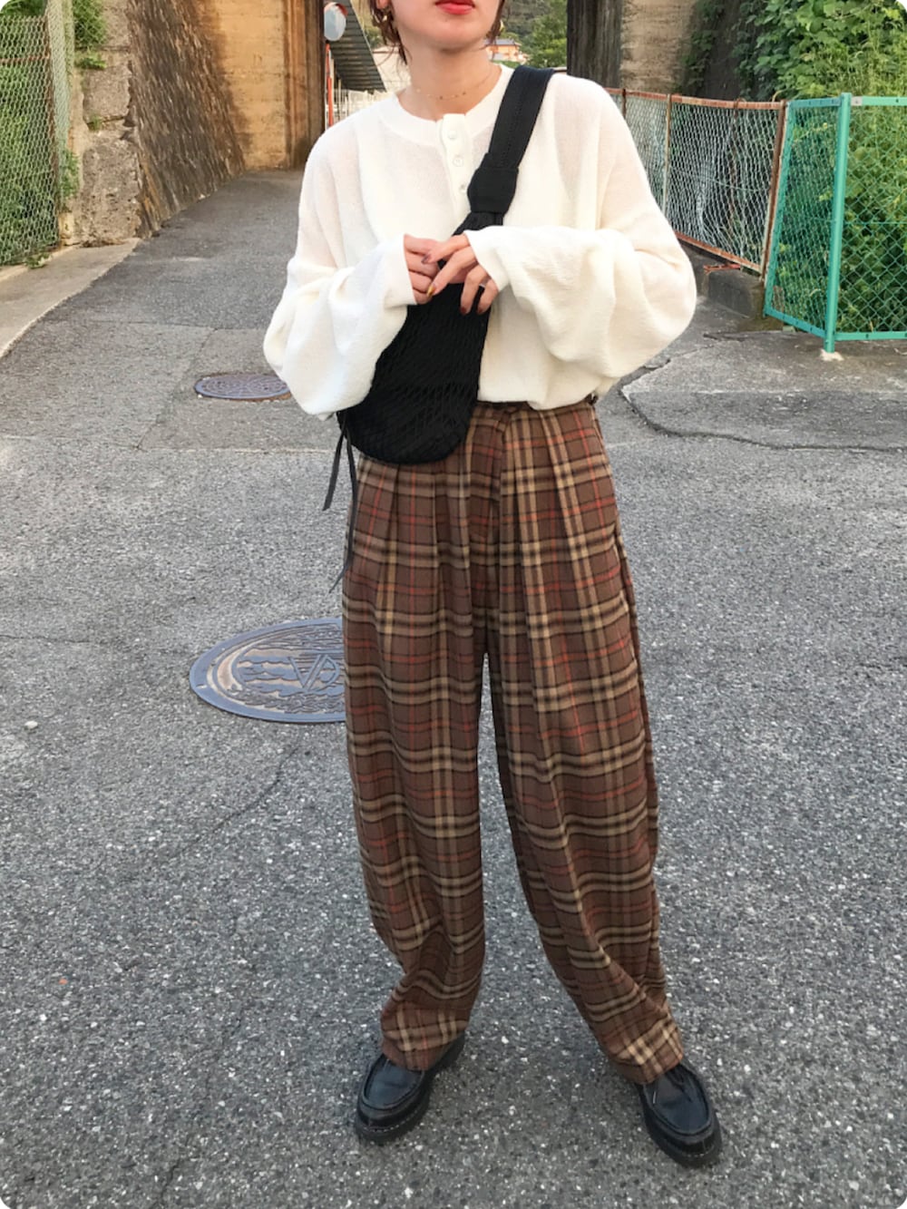 ブラック系のショルダーバッグ、ブラック系のその他シューズ、ホワイト系のトップスを着用したレディースの夏コーディネートの2枚目の写真