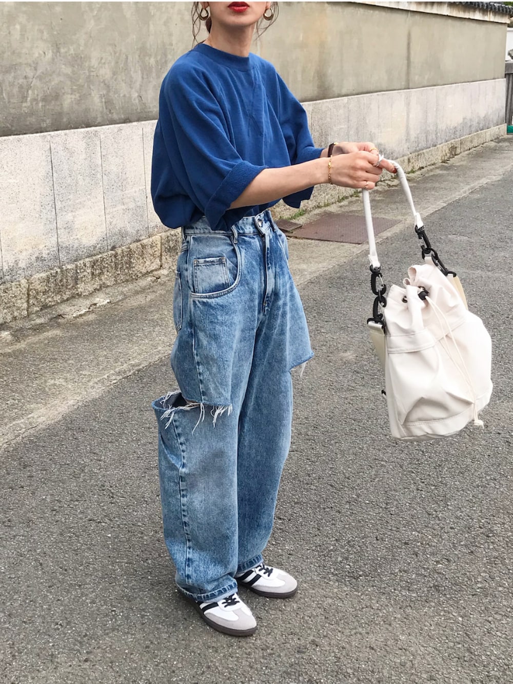 ブルー系のTシャツ/カットソー、ブルー系のデニムパンツ、ホワイト系のショルダーバッグを着用したレディースの春コーディネートの3枚目の写真