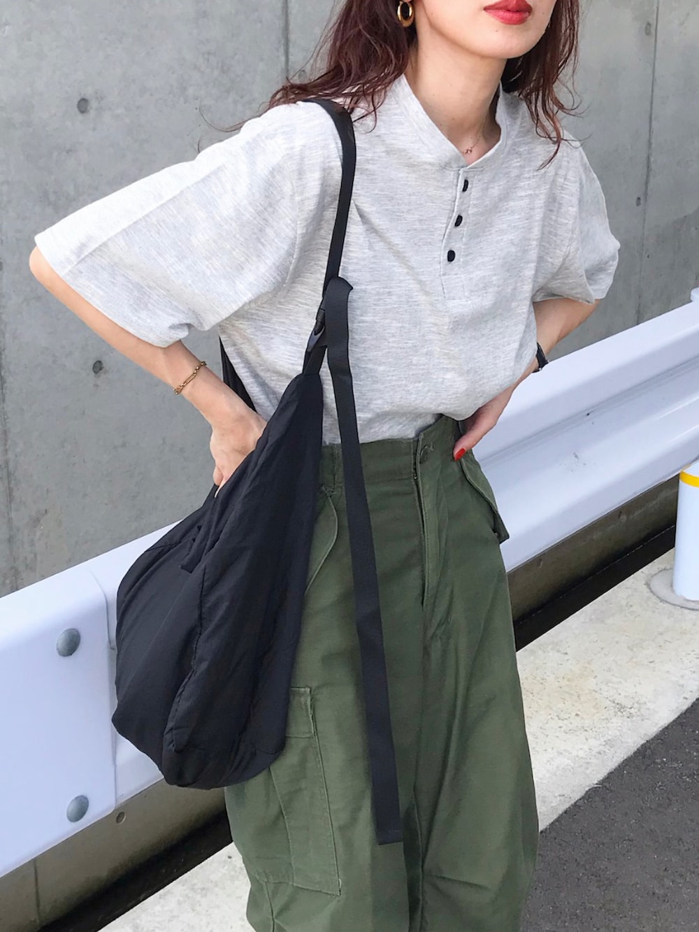 グレー系のTシャツ/カットソー、グリーン系のカーゴパンツ、ブラック系のショルダーバッグを着用したレディースの夏コーディネートの2枚目の写真