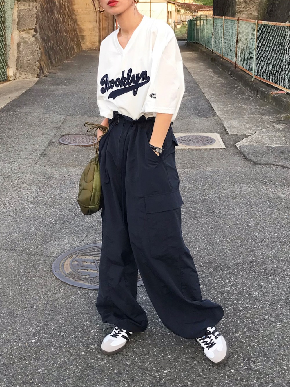 ホワイト系のトップス、ブルー系のオールインワン・サロペット、ホワイト系のスニーカーを着用したレディースの夏コーディネートの2枚目の写真