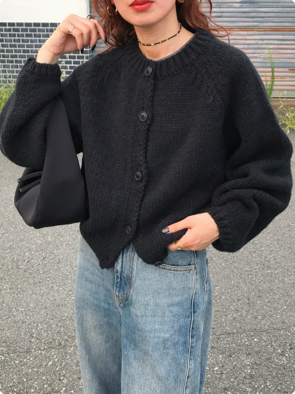 ブラック系のハンドバッグ、ホワイト系のスニーカー、ブラック系のカーディガン/ボレロを着用したレディースの秋コーディネートの2枚目の写真