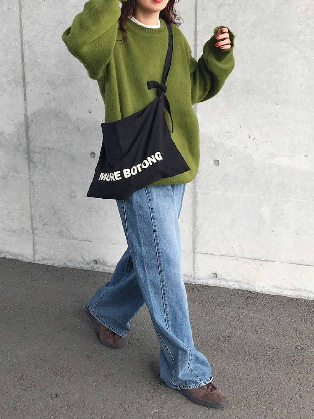 グリーン系のニット/セーター、ホワイト系のTシャツ/カットソー、ブラック系のショルダーバッグを着用したレディースの秋コーディネートの3枚目の写真