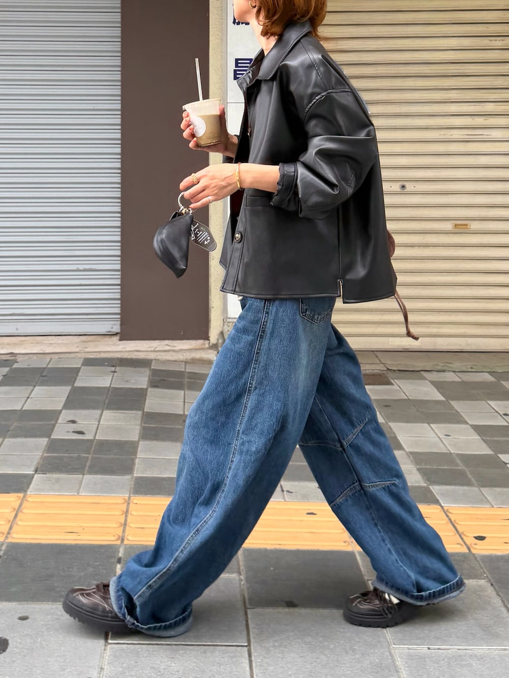 ブラック系のジャケット/アウター、レッド系のタンクトップ、ブルー系のデニムパンツを着用したレディースの秋コーディネートの3枚目の写真