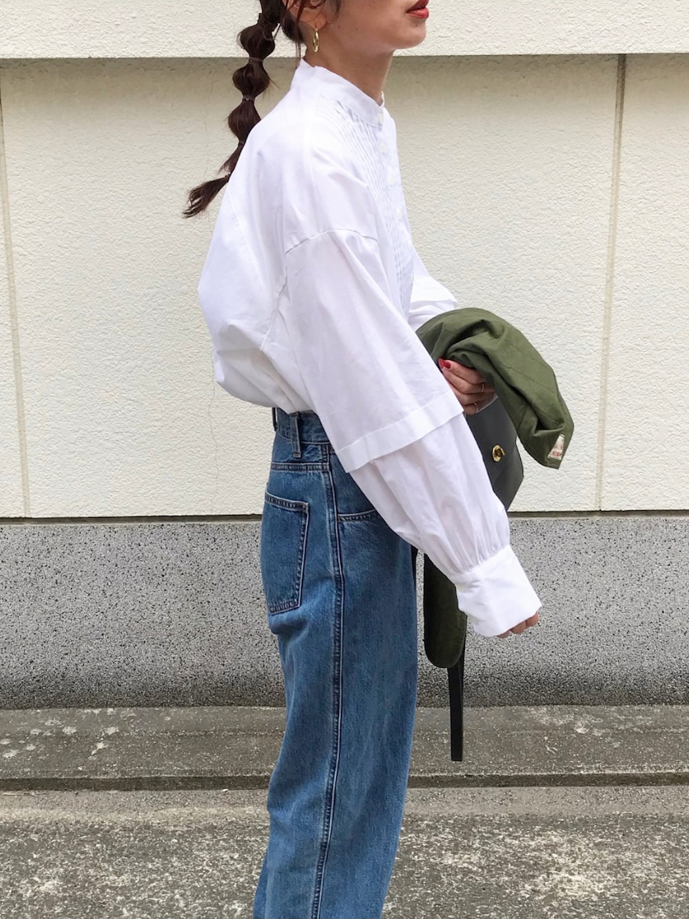 グリーン系のベスト、ホワイト系のシャツ/ブラウス、ブルー系のデニムパンツを着用したレディースの春コーディネートの3枚目の写真