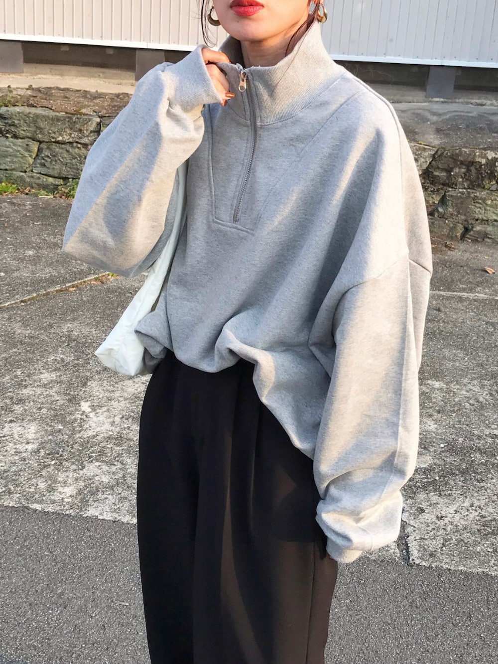 グレー系のスウェット、ベージュ系のTシャツ/カットソー、ブラック系のスラックスを着用したレディースの春コーディネートの2枚目の写真